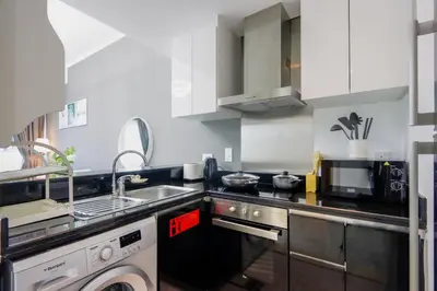 a kitchen with a sink and a washing machine at 1BR with Balcony, Steps from JBR & Marina Walk in Dubai