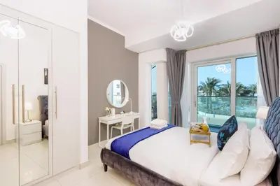 a bedroom with a large bed and a mirror at 1BR with Balcony, Steps from JBR & Marina Walk in Dubai