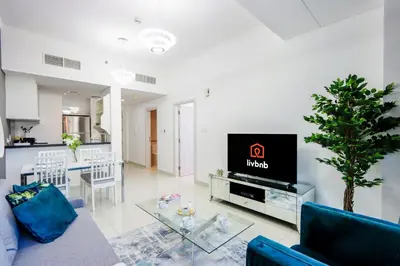 a living room with a tv and a dining room at 1BR with Balcony, Steps from JBR & Marina Walk in Dubai