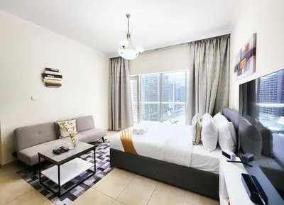 a bedroom with a bed and a couch and a window at RH- Contemporary Living, Studio, Near Burj Khalifa in Dubai