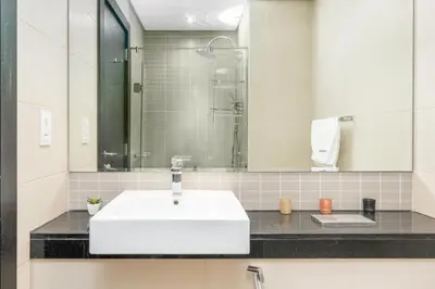a bathroom with a white sink and a mirror at Gala Guests - Silverene Tower Marina Living Apartments in Dubai