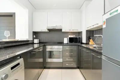 a kitchen with white cabinets and stainless steel appliances at Gala Guests - Silverene Tower Marina Living Apartments in Dubai