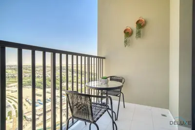 a balcony with a table and chairs and a view at Tranquil 2BR with Assistant Room at Mesk 1 Midtown Dubai Production City by Deluxe Holiday Homes in Dubai