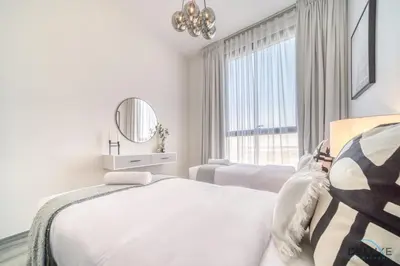 a white bedroom with a bed and a mirror at Tranquil 2BR with Assistant Room at Mesk 1 Midtown Dubai Production City by Deluxe Holiday Homes in Dubai