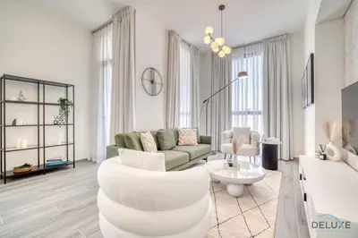 a living room with a couch and a chair at Tranquil 2BR with Assistant Room at Mesk 1 Midtown Dubai Production City by Deluxe Holiday Homes in Dubai