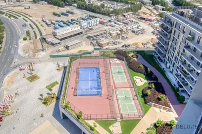 an aerial view of a building with a tennis court at Peaceful 2BR with Assistant Room at Mesk 1 Midtown Dubai Production City by Deluxe Holiday Homes in Dubai
