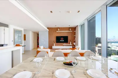 a dining room and living room with a table and chairs at Livbnb - Alluring 3BR Plus Maid's with Sea & Ain Dubai View in Dubai