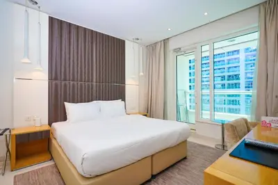 a hotel room with a bed and a window at Alashrafia Saray- Splendid 1BR apartment in Canal Views in Dubai