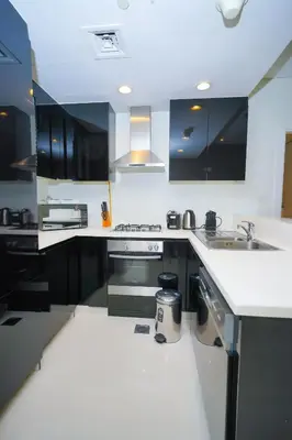 a kitchen with black cabinets and a white counter top at Alashrafia Saray- Splendid 1BR apartment in Canal Views in Dubai