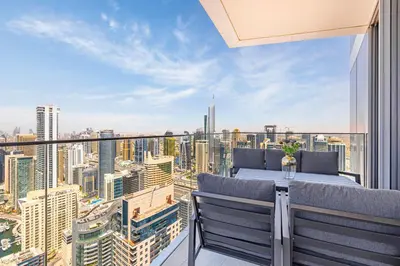 a balcony with a table and chairs and a city skyline at Daniels Marina View 4BR Duplex in Stella Maris in Dubai