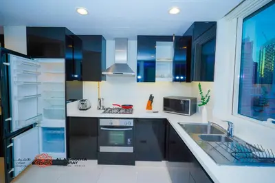 a kitchen with a sink and a stove top oven at Alashrafia Saray- Cozy 2BR apartment in Canal Views in Dubai