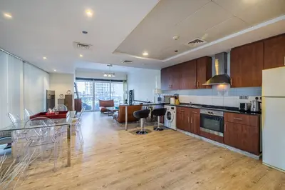 a kitchen and living room with a table and chairs at Spacious Apartment I Lake Views Apartment in JLT I Close To Metro in Dubai
