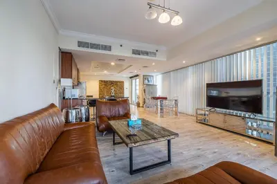 a living room with a leather couch and a table at Spacious Apartment I Lake Views Apartment in JLT I Close To Metro in Dubai