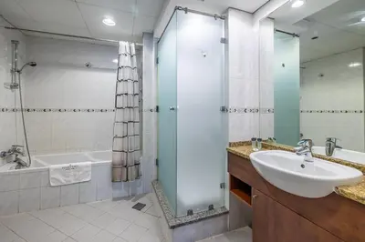 a bathroom with a sink and a shower and a tub at Spacious Apartment I Lake Views Apartment in JLT I Close To Metro in Dubai