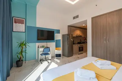 a bedroom with a large bed and a kitchen at Izzzi Life Mint in Dubai