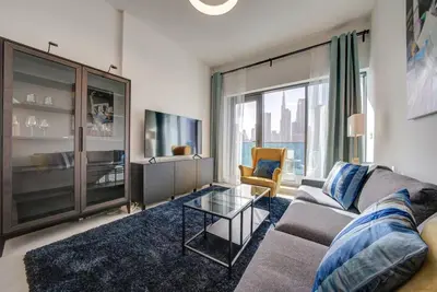 a living room with a couch and a tv at Canal View l Stylish & Spacious in Dubai