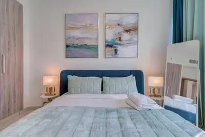 a bedroom with a bed with three paintings on the wall at Canal View l Stylish & Spacious in Dubai