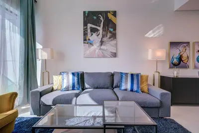 a living room with a couch and a glass table at Canal View l Stylish & Spacious in Dubai