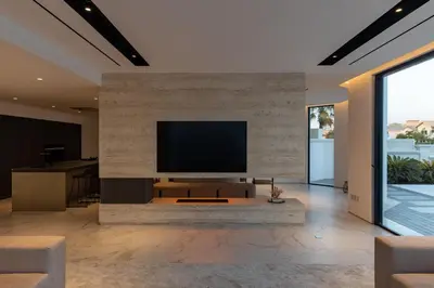 a living room with a flat screen tv on a stone wall at Palm Jumeirah Paradise - 5BR Villa - Infinity Pool in Dubai