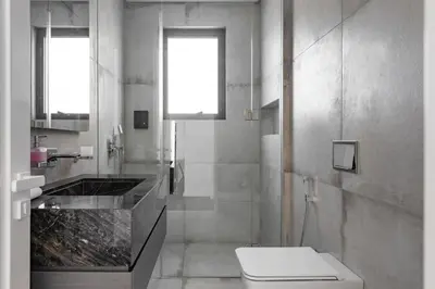 a white bathroom with a toilet and a sink at Palm Jumeirah Paradise - 5BR Villa - Infinity Pool in Dubai