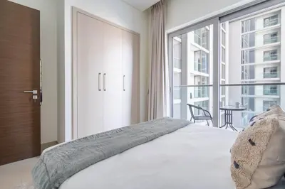 a bedroom with a bed and a large window at GuestReady Holiday Homes - Sobha Urban Retreat in Dubai