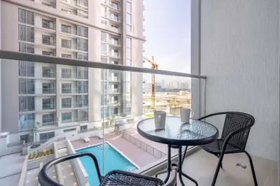 a balcony with a table and chairs and a large window at GuestReady Holiday Homes - Sobha Urban Retreat in Dubai