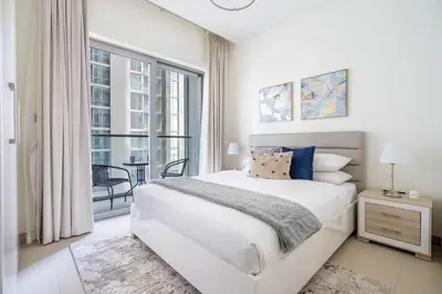 a white bedroom with a large bed and a large window at GuestReady Holiday Homes - Sobha Urban Retreat in Dubai