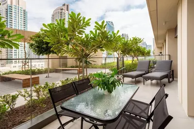a balcony with a table and chairs and palm trees at Prime Retreats @ Burj Royale By Emaar in Dubai