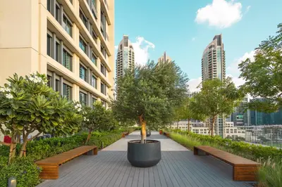 a walkway with benches and trees in a city at Prime Retreats @ Burj Royale By Emaar in Dubai