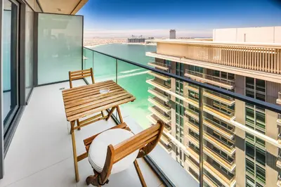 a balcony with a bench and a table on a building at Bright and cozy 1BD apartment on the Beachfront in Dubai