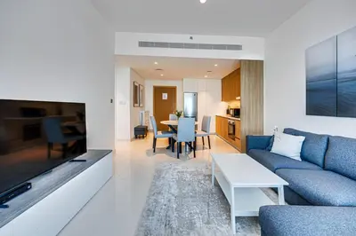a living room with a couch and a table at Bright and cozy 1BD apartment on the Beachfront in Dubai