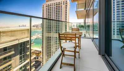 a balcony with a table and chairs and views of the city at Bright and cozy 1BD apartment on the Beachfront in Dubai