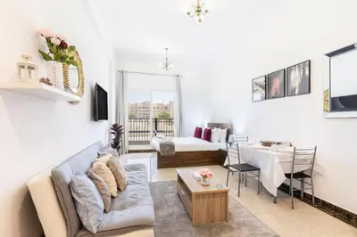 a living room with a couch and a table at Lower floor studio with a sofa bed in JVC - Allsopp&Allsopp in Dubai