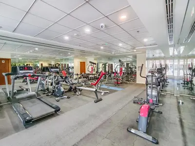 a gym with a lot of treadmills and machines at Lower floor studio with a sofa bed in JVC - Allsopp&Allsopp in Dubai