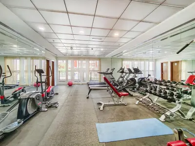 a gym with lots of treadmills and machines at Lower floor studio with a sofa bed in JVC - Allsopp&Allsopp in Dubai