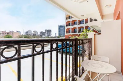 a balcony with a table and chairs and a view of the city at Lower floor studio with a sofa bed in JVC - Allsopp&Allsopp in Dubai