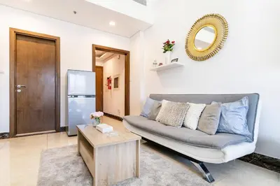 a living room with a couch and a mirror at Lower floor studio with a sofa bed in JVC - Allsopp&Allsopp in Dubai