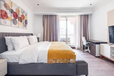 a bedroom with a bed and a desk and a television at Spacious 2-bedroom beachfront apartment with pool in Dubai