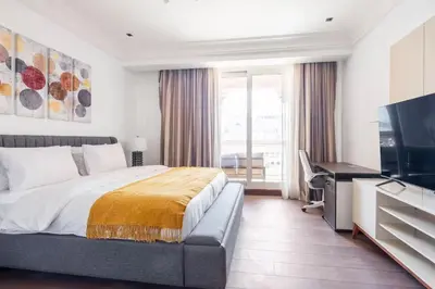 a bedroom with a bed and a flat screen tv at Spacious 2-bedroom beachfront apartment with pool in Dubai