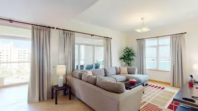 a living room with a couch and a large window at Al Dabas Beach Views, 3BD Sleeps 6, Beachfront Beach & Pool Access - DVH Holiday Homes in Dubai