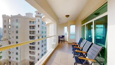 a balcony with chairs and a view of a building at Al Dabas Beach Views, 3BD Sleeps 6, Beachfront Beach & Pool Access - DVH Holiday Homes in Dubai