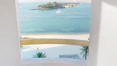 a view of a beach from a window at Al Dabas Beach Views, 3BD Sleeps 6, Beachfront Beach & Pool Access - DVH Holiday Homes in Dubai