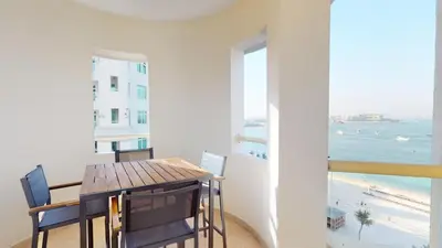 a dining room with a table and a view of the beach at Al Dabas Beach Views, 3BD Sleeps 6, Beachfront Beach & Pool Access - DVH Holiday Homes in Dubai
