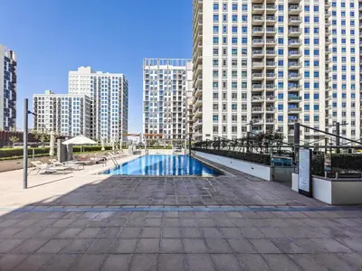 a swimming pool in a city with tall buildings at Chic 1BR in Park Heights 2 - Dubai Hills in Dubai