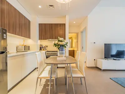 a kitchen with a table with a vase of flowers on it at Chic 1BR in Park Heights 2 - Dubai Hills in Dubai