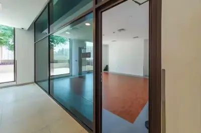 an empty room with glass doors in a building at Vogue Madinat Jumeirah Living Rahaal Near Burj Al Arab One Bedroom Apartment with Balcony and Vibrant Community View, Access to all Amenities in Dubai