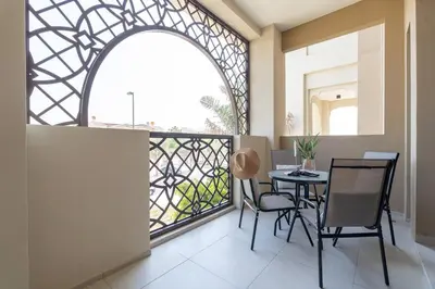 a balcony with a table and chairs and a window at Vogue Madinat Jumeirah Living Rahaal Near Burj Al Arab One Bedroom Apartment with Balcony and Vibrant Community View, Access to all Amenities in Dubai