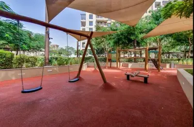 a swing yard with a bench and an umbrella at Vogue Madinat Jumeirah Living Rahaal Near Burj Al Arab One Bedroom Apartment with Balcony and Vibrant Community View, Access to all Amenities in Dubai