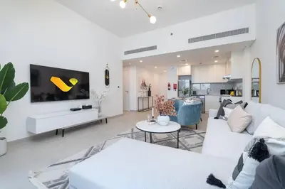 a living room with a white couch and a tv at Vogue Madinat Jumeirah Living Rahaal Near Burj Al Arab One Bedroom Apartment with Balcony and Vibrant Community View, Access to all Amenities in Dubai