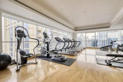a gym with a row of treadmills and ellipticals at GuestReady - Luxe Studio with JLT Park View in Dubai